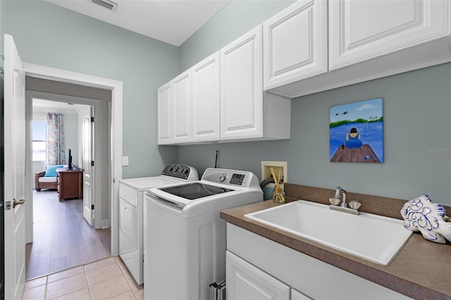 6136 Lake Emma Rd, Groveland, FL 34736 - laundry area featuring washing machine and clothes dryer, cabinet space, and light tile patterned flooring