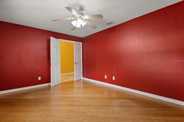 5729 Bible Camp Rd, Groveland, FL 34736 - unfurnished room featuring light wood-style flooring, a ceiling fan, and a textured wall