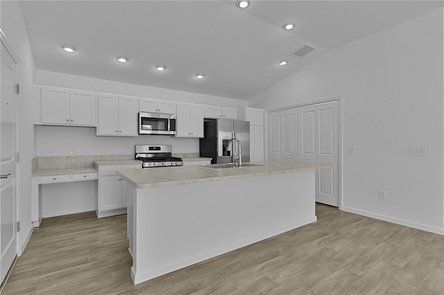 3283 Dawn Pl, The Villages, FL 32163 - kitchen with stainless steel appliances, light countertops, lofted ceiling, white cabinets, and a kitchen island with sink