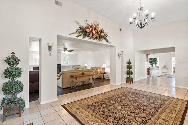 81 N Carol Ave, Mascotte, FL 34753 - foyer entrance featuring light tile patterned flooring, a towering ceiling, a chandelier, and a ceiling fan