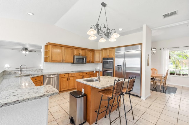 81 N Carol Ave, Mascotte, FL 34753 - kitchen featuring appliances with stainless steel finishes, light tile patterned flooring, vaulted ceiling, light stone countertops, and backsplash
