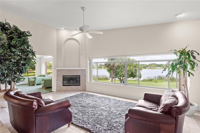 81 N Carol Ave, Mascotte, FL 34753 - living area featuring light tile patterned flooring, a water view, ceiling fan, a tile fireplace, and a towering ceiling