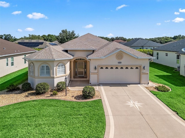 10927 SE 168th Loop, Summerfield, FL 34491 - mediterranean / spanish home with a shingled roof, driveway, a garage, a front yard, and stucco siding