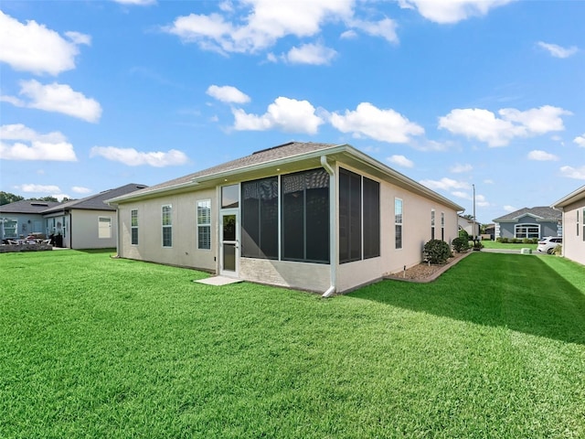 10927 SE 168th Loop, Summerfield, FL 34491 - back of house featuring a lawn, a sunroom, and stucco siding