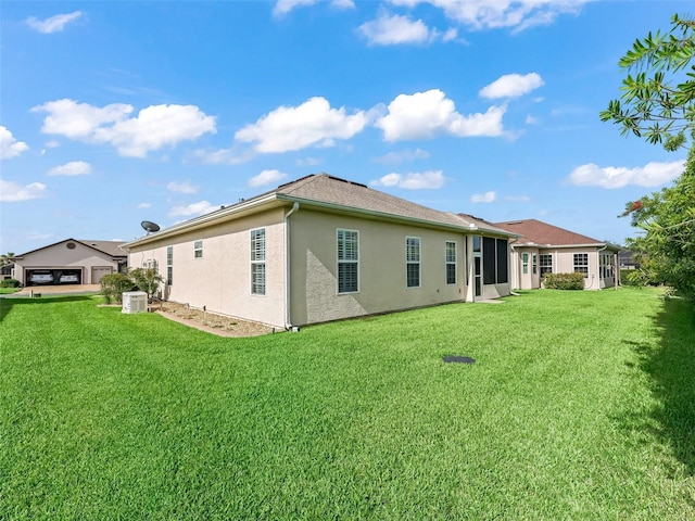 10927 SE 168th Loop, Summerfield, FL 34491 - rear view of house featuring stucco siding and a lawn