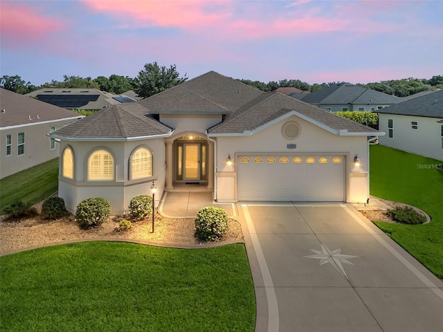 10927 SE 168th Loop, Summerfield, FL 34491 - view of front of home with stucco siding, concrete driveway, a lawn, and an attached garage