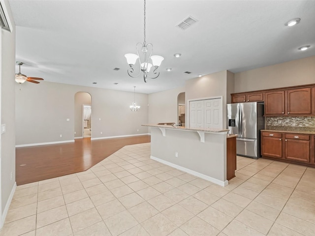10927 SE 168th Loop, Summerfield, FL 34491 - kitchen with stainless steel fridge, arched walkways, a chandelier, light tile patterned flooring, and recessed lighting