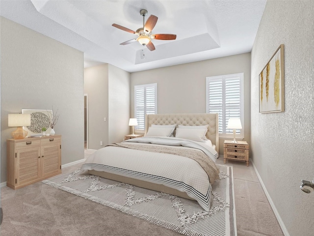 10927 SE 168th Loop, Summerfield, FL 34491 - bedroom with a textured wall, a tray ceiling, light colored carpet, and ceiling fan