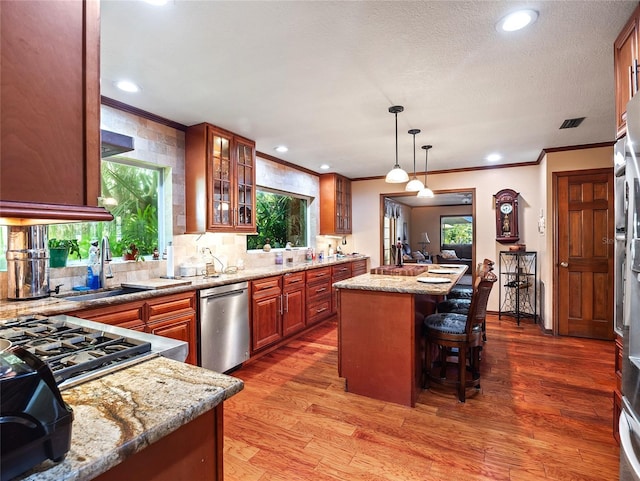 15733 Tower View Dr, Clermont, FL 34711 - kitchen with dishwasher, crown molding, tasteful backsplash, a kitchen island, and light wood finished floors