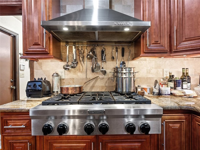 15733 Tower View Dr, Clermont, FL 34711 - kitchen featuring wall chimney exhaust hood, stainless steel gas stovetop, decorative backsplash, and light stone countertops