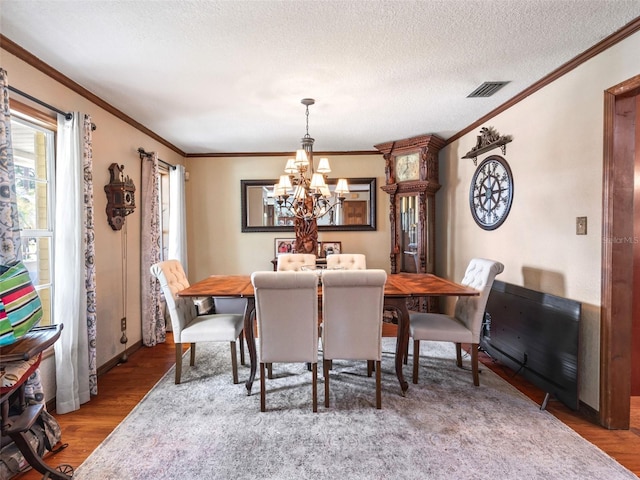 15733 Tower View Dr, Clermont, FL 34711 - dining space with a chandelier, wood finished floors, ornamental molding, and a textured ceiling