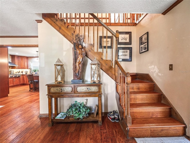 15733 Tower View Dr, Clermont, FL 34711 - staircase with wood finished floors, a textured ceiling, and crown molding