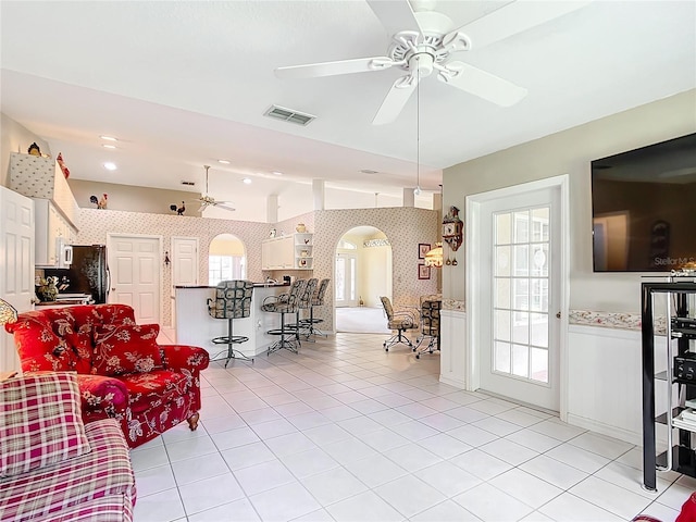 13700 SE 90th Ct, Summerfield, FL 34491 - living area with arched walkways, a ceiling fan, light tile patterned flooring, vaulted ceiling, and wallpapered walls