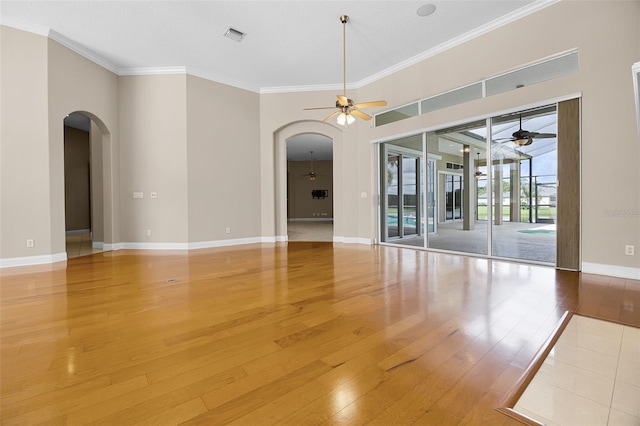 7303 Spring Mountain Ln, Yalaha, FL 34797 - unfurnished room featuring arched walkways, ceiling fan, wood finished floors, and ornamental molding