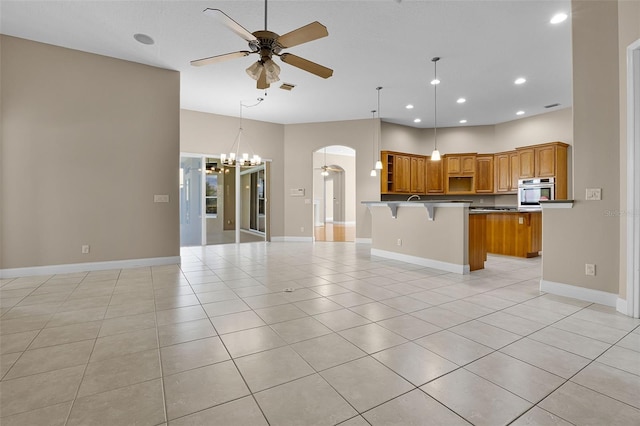 7303 Spring Mountain Ln, Yalaha, FL 34797 - kitchen with open floor plan, a ceiling fan, arched walkways, oven, and a breakfast bar