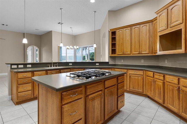 7303 Spring Mountain Ln, Yalaha, FL 34797 - kitchen with stainless steel gas stovetop, open shelves, dark countertops, and light tile patterned floors