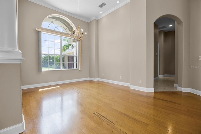 7303 Spring Mountain Ln, Yalaha, FL 34797 - unfurnished room with arched walkways, light wood-style flooring, crown molding, and a chandelier