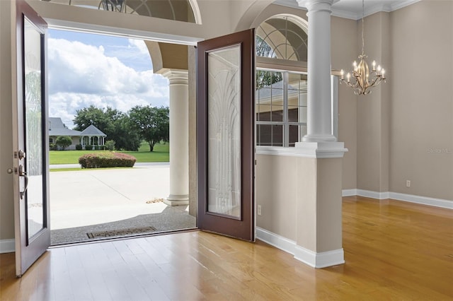 7303 Spring Mountain Ln, Yalaha, FL 34797 - foyer featuring decorative columns, wood finished floors, healthy amount of natural light, and crown molding