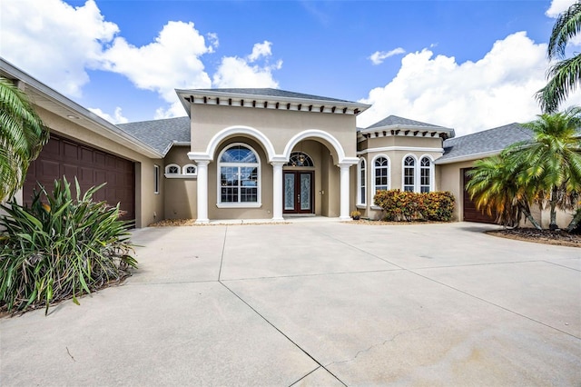 7303 Spring Mountain Ln, Yalaha, FL 34797 - mediterranean / spanish house featuring french doors, driveway, an attached garage, and stucco siding