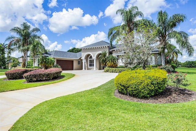 7303 Spring Mountain Ln, Yalaha, FL 34797 - mediterranean / spanish home featuring a garage, stucco siding, a front lawn, and concrete driveway