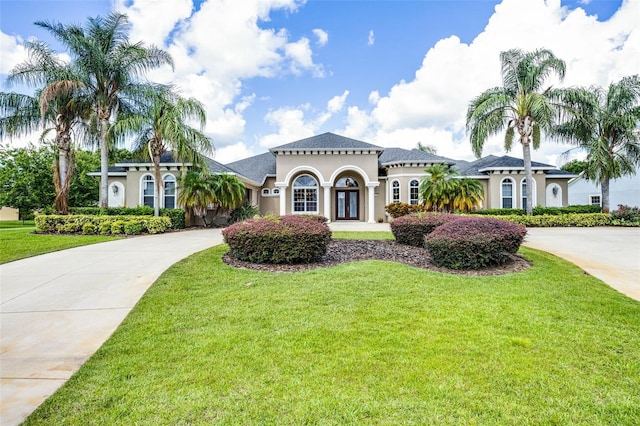 7303 Spring Mountain Ln, Yalaha, FL 34797 - mediterranean / spanish-style house with stucco siding, a front yard, and driveway