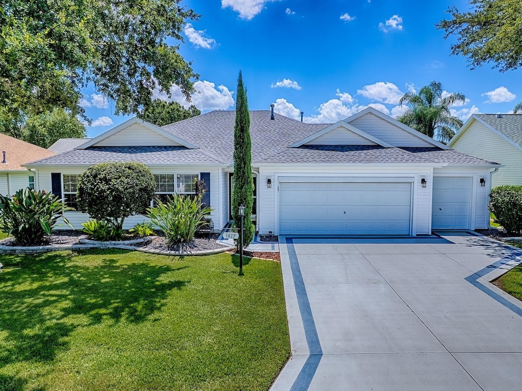 1419 Arbor Trl, The Villages, FL 32162 - ranch-style home with an attached garage, roof with shingles, a front yard, and concrete driveway