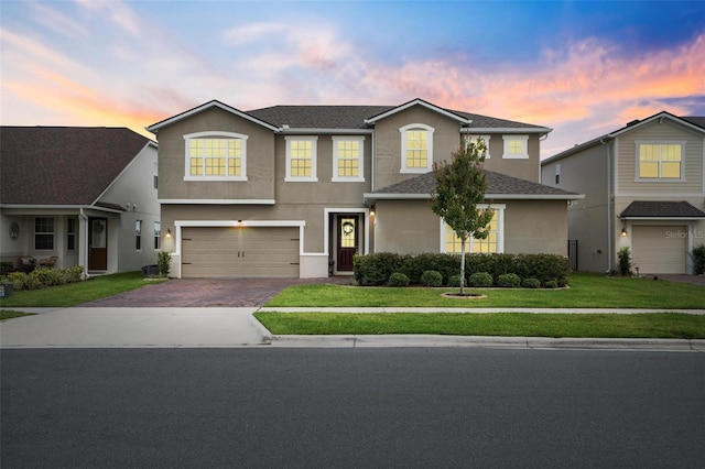 3304 Canna Lily Pl, Clermont, FL 34711 - traditional home featuring an attached garage, decorative driveway, stucco siding, and a front yard