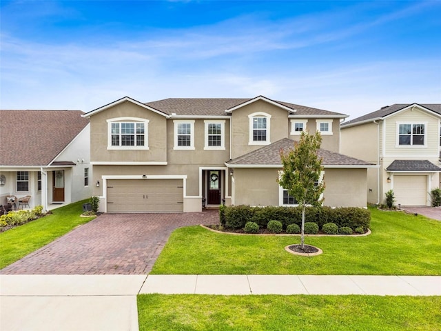 3304 Canna Lily Pl, Clermont, FL 34711 - view of front of property featuring decorative driveway, stucco siding, an attached garage, and a front yard