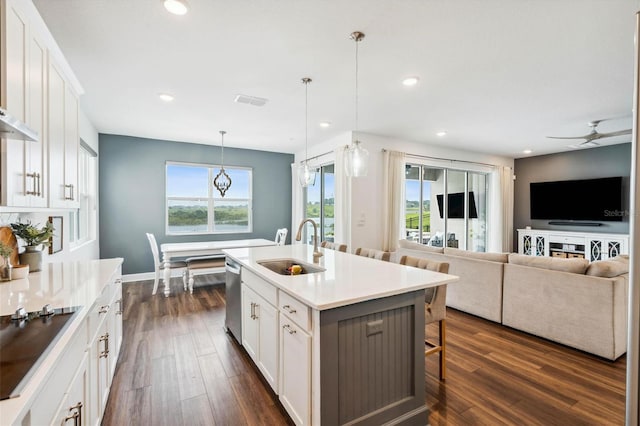 3304 Canna Lily Pl, Clermont, FL 34711 - kitchen with black electric stovetop, dark wood finished floors, a kitchen bar, stainless steel dishwasher, and a ceiling fan