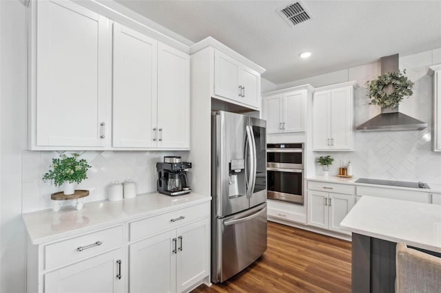 3304 Canna Lily Pl, Clermont, FL 34711 - kitchen with appliances with stainless steel finishes, wall chimney range hood, light countertops, white cabinets, and recessed lighting