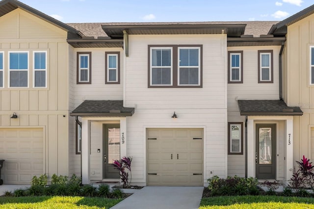 709 Longboat Dr, Davenport, FL 33896 - townhome / multi-family property featuring board and batten siding, roof with shingles, and a garage