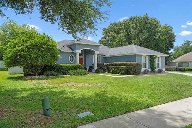 14708 Timucua Pl, Clermont, FL 34711 - view of front of home with stucco siding, a front yard, and roof with shingles