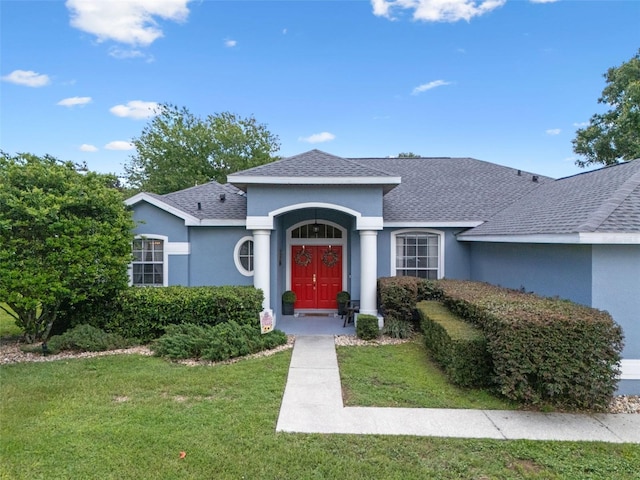 14708 Timucua Pl, Clermont, FL 34711 - view of front of property featuring stucco siding, a front lawn, and a shingled roof