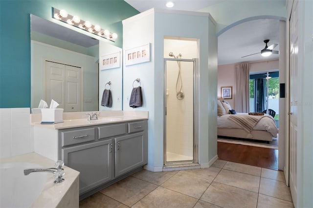 14708 Timucua Pl, Clermont, FL 34711 - full bath featuring a shower stall, tile patterned floors, vanity, a garden tub, and a ceiling fan