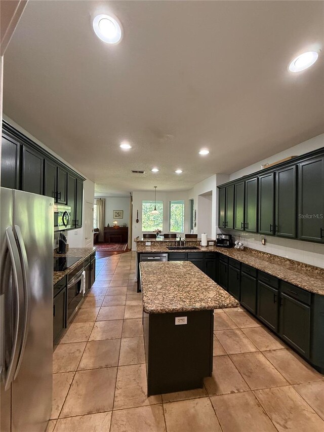26620 Shoregrass Dr, Wesley Chapel, FL 33544 - kitchen featuring stainless steel appliances, a peninsula, a center island, recessed lighting, and stone counters