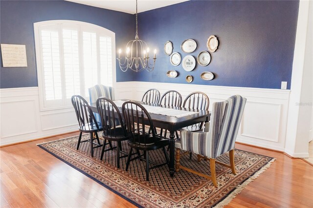 26620 Shoregrass Dr, Wesley Chapel, FL 33544 - dining room with a chandelier, wood finished floors, a wainscoted wall, and a decorative wall