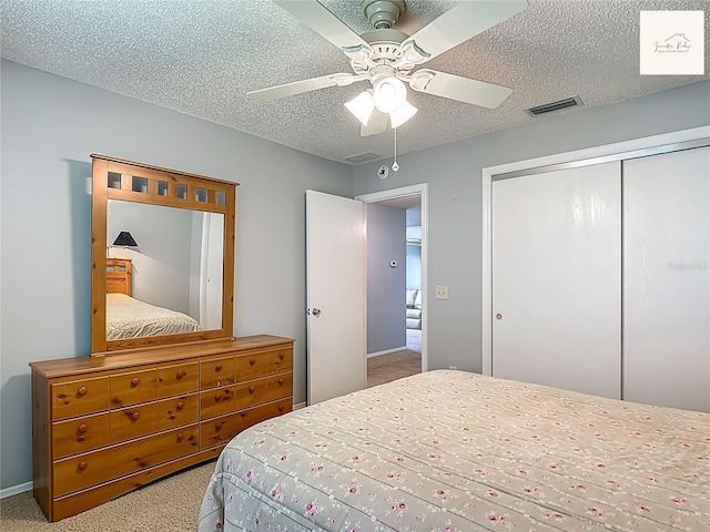 2311 Pine Ridge St, The Villages, FL 32162 - bedroom featuring carpet floors, a closet, a textured ceiling, and a ceiling fan