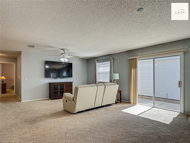 2311 Pine Ridge St, The Villages, FL 32162 - carpeted living room featuring ceiling fan and a textured ceiling