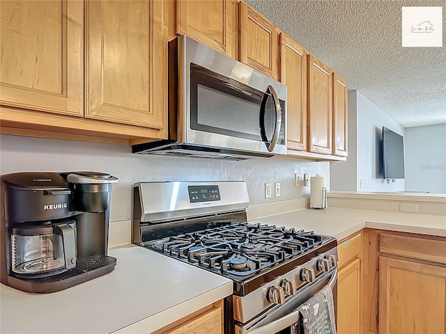 2311 Pine Ridge St, The Villages, FL 32162 - kitchen with appliances with stainless steel finishes, a textured ceiling, and light countertops
