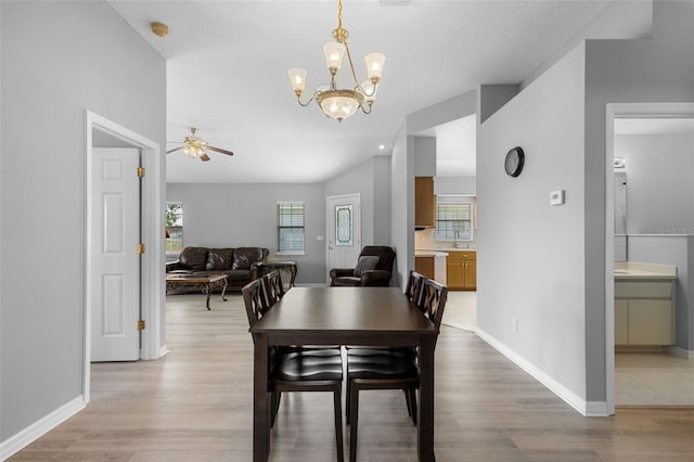 5715 Illumination Ln, Leesburg, FL 34748 - dining area featuring a ceiling fan, light wood-style floors, a chandelier, and vaulted ceiling