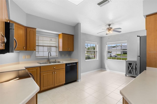 5715 Illumination Ln, Leesburg, FL 34748 - kitchen with stainless steel appliances, a ceiling fan, brown cabinetry, and a textured ceiling