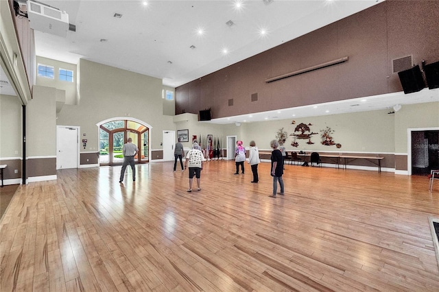 5715 Illumination Ln, Leesburg, FL 34748 - workout room featuring a towering ceiling, hardwood / wood-style floors, and recessed lighting
