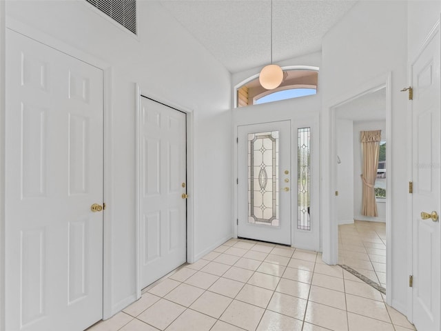 1142 W Boone Ct, The Villages, FL 32159 - foyer featuring light tile patterned floors and a textured ceiling