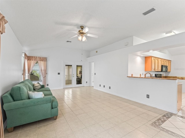1142 W Boone Ct, The Villages, FL 32159 - living area featuring light tile patterned floors, ceiling fan, lofted ceiling, a textured ceiling, and french doors