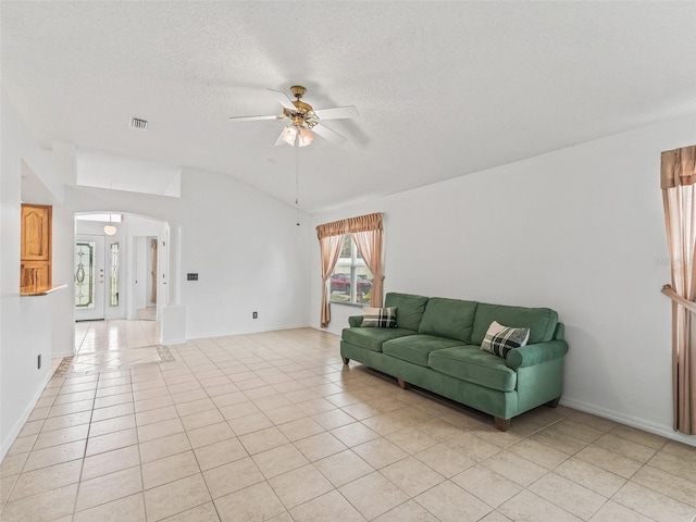 1142 W Boone Ct, The Villages, FL 32159 - living area with arched walkways, a ceiling fan, light tile patterned floors, vaulted ceiling, and a textured ceiling