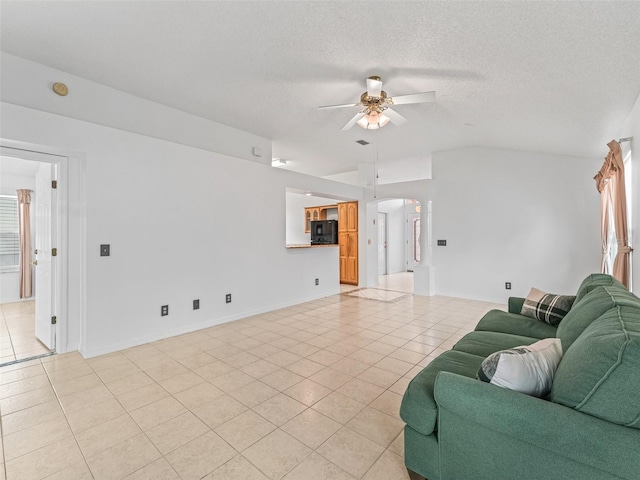 1142 W Boone Ct, The Villages, FL 32159 - living room featuring light tile patterned floors, a ceiling fan, vaulted ceiling, and a textured ceiling