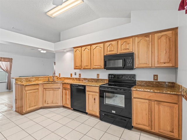 1142 W Boone Ct, The Villages, FL 32159 - kitchen with black appliances, a peninsula, dark stone countertops, light tile patterned flooring, and vaulted ceiling