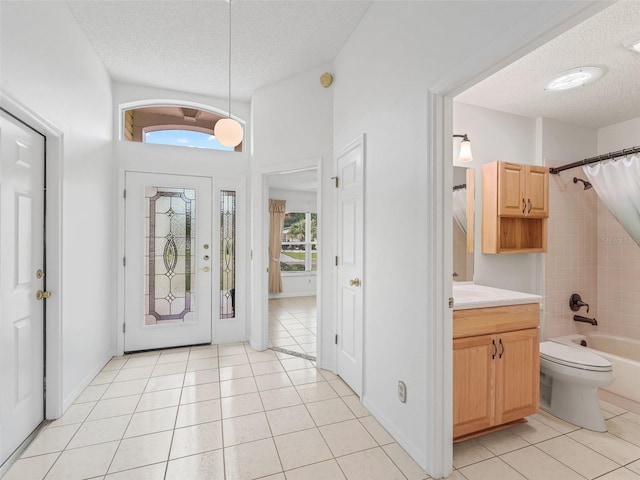 1142 W Boone Ct, The Villages, FL 32159 - foyer with a textured ceiling and light tile patterned flooring