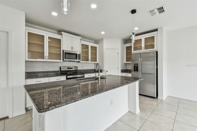 2139 Stellar Brilliance Way, Lutz, FL 33558 - kitchen featuring stainless steel appliances, light tile patterned floors, white cabinetry, a kitchen island with sink, and pendant lighting