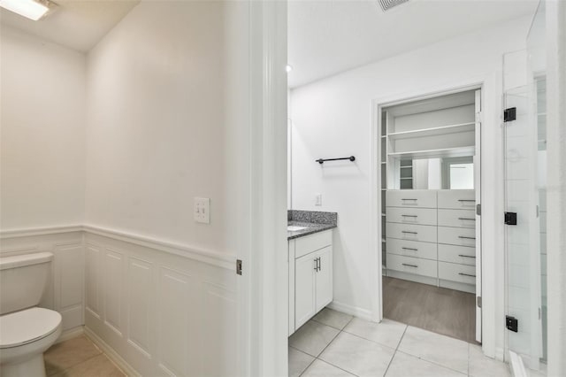 2139 Stellar Brilliance Way, Lutz, FL 33558 - bathroom with vanity, tile patterned floors, a wainscoted wall, and a decorative wall